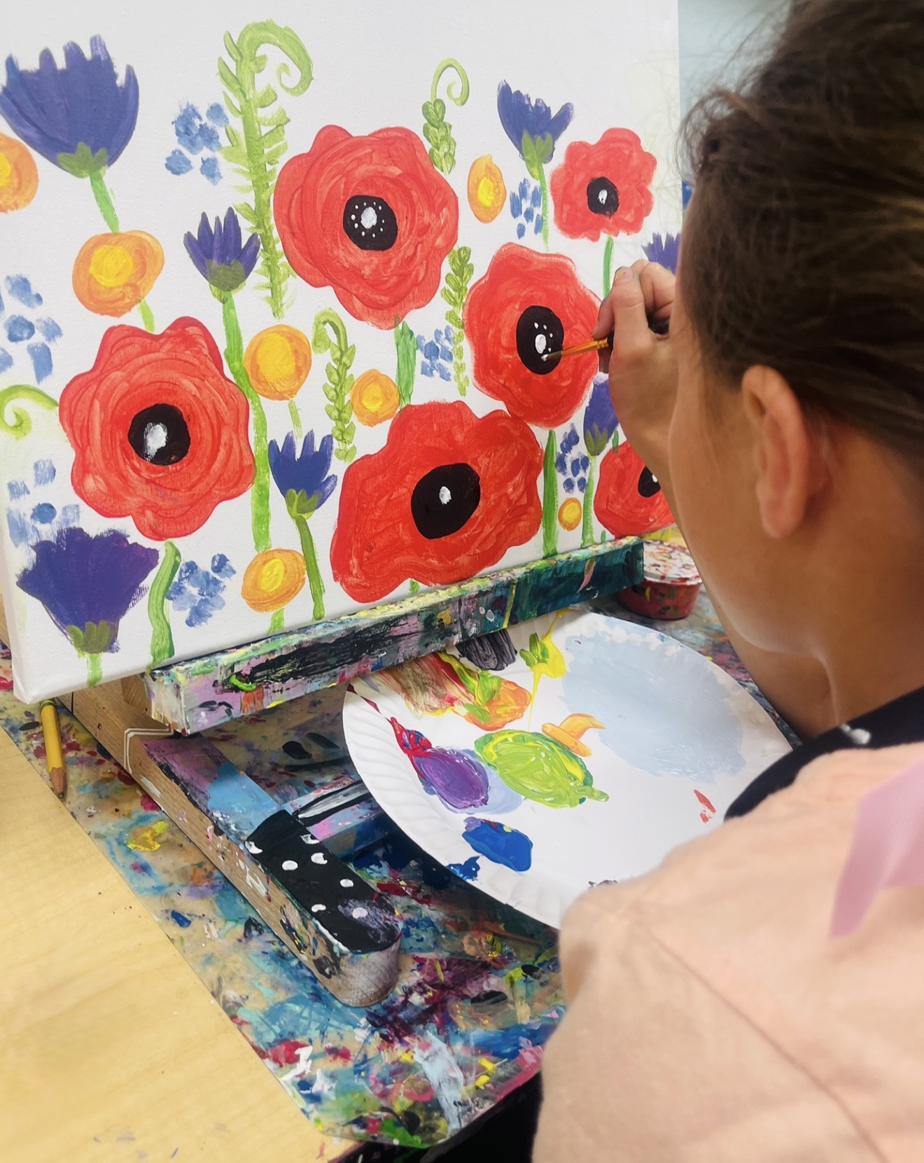 Student painting flowers in an Art Planet class